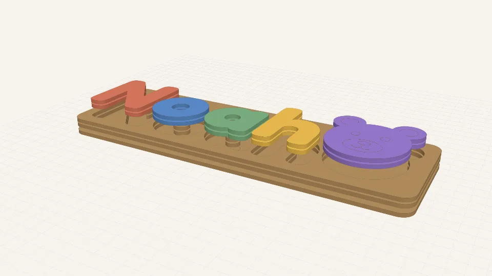 A laser-cut name puzzle: the colourful letters of the name Noah and a bear's head lifted out of a wooden tray